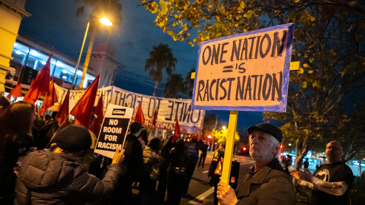 Protesters against One Nation hold placards.