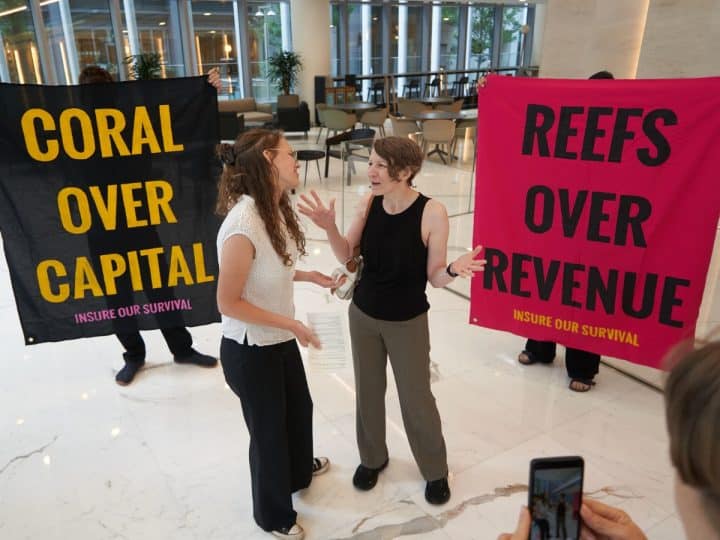 Boycott Bloody Insurance activists in the lobby of the Walkie Talkie. Banners say: Coral Over Capital and Reefs Over Revenue
