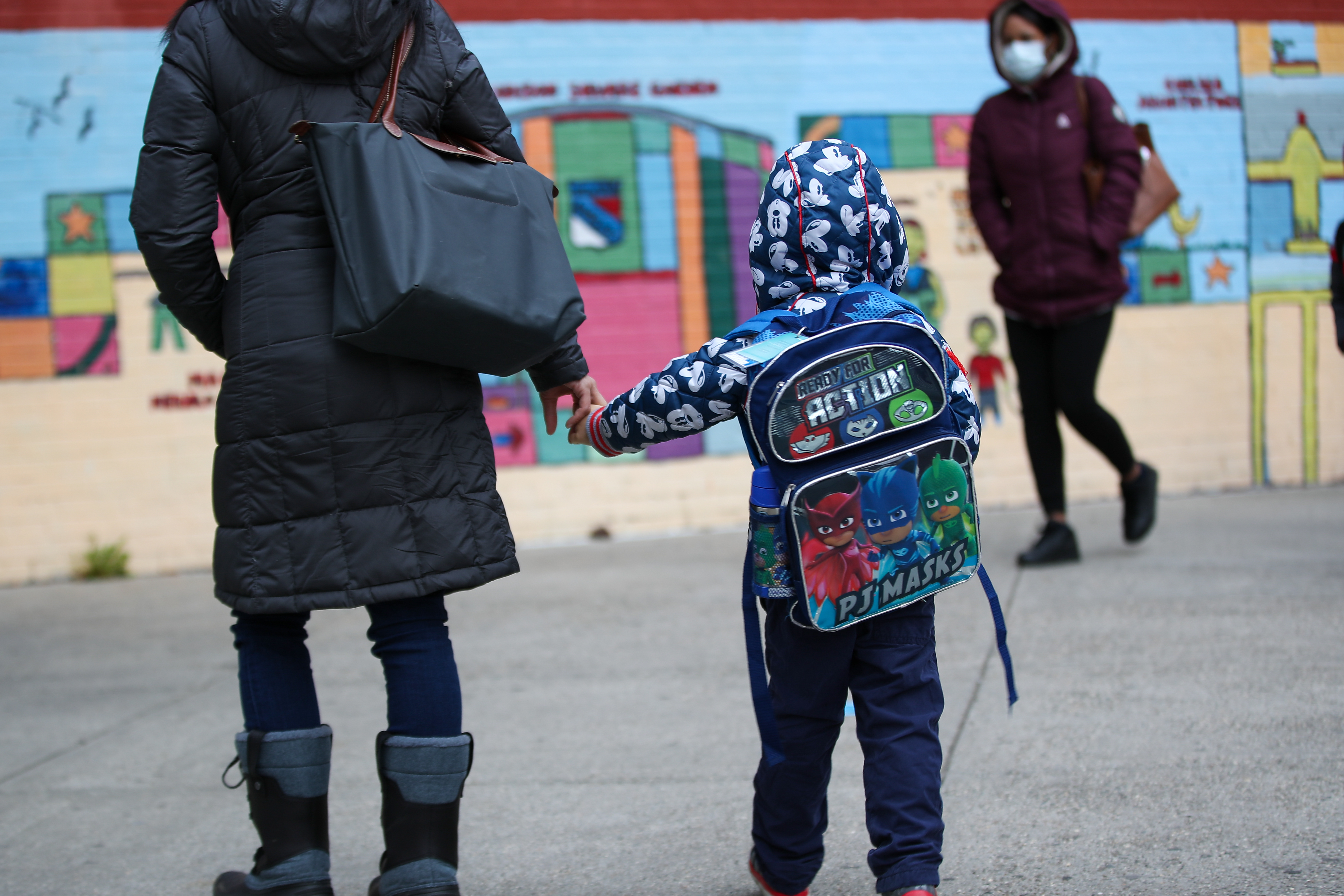 A woman and her child stand on the street in New York City.