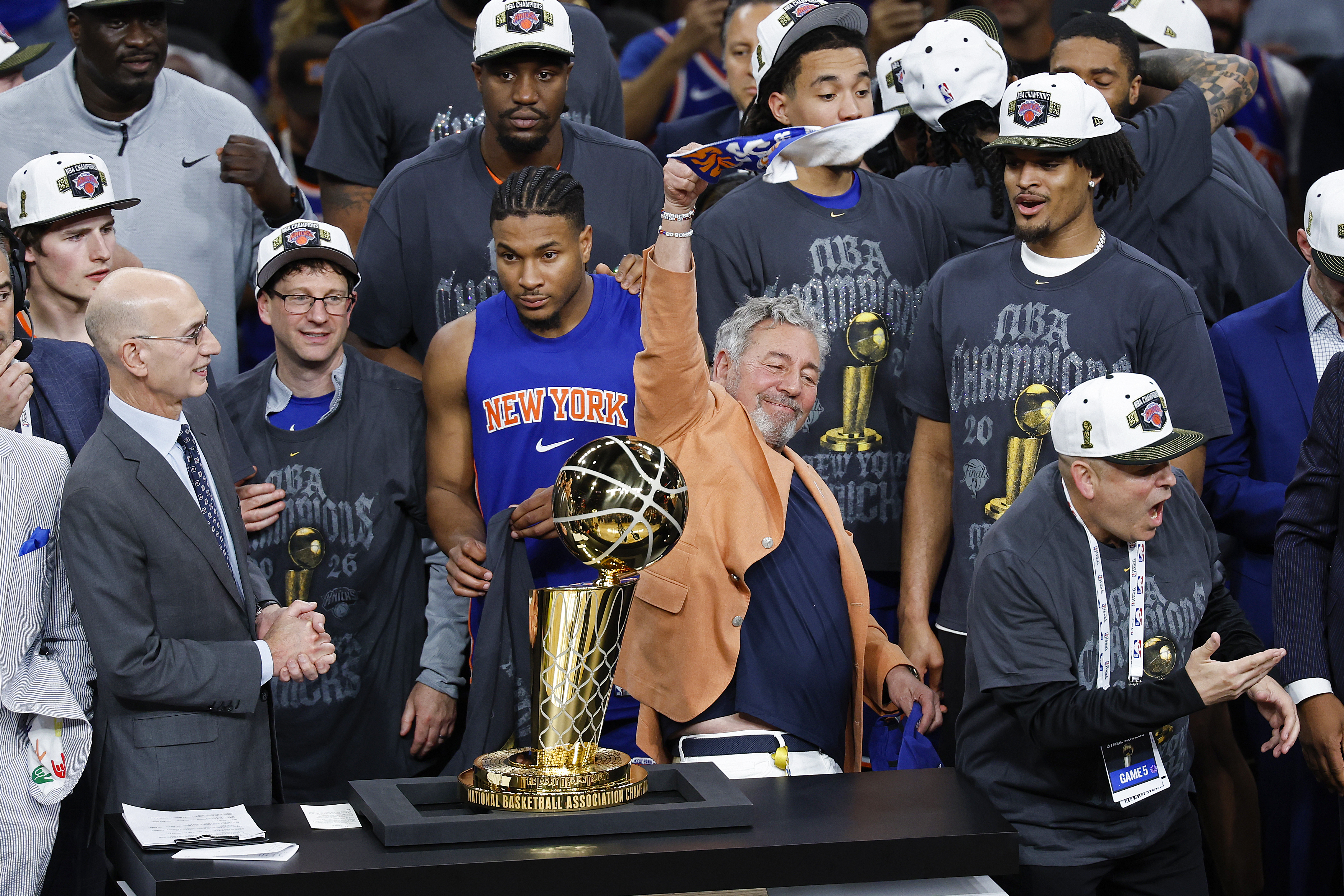James Dolan celebrates with a trophy and Knicks players.