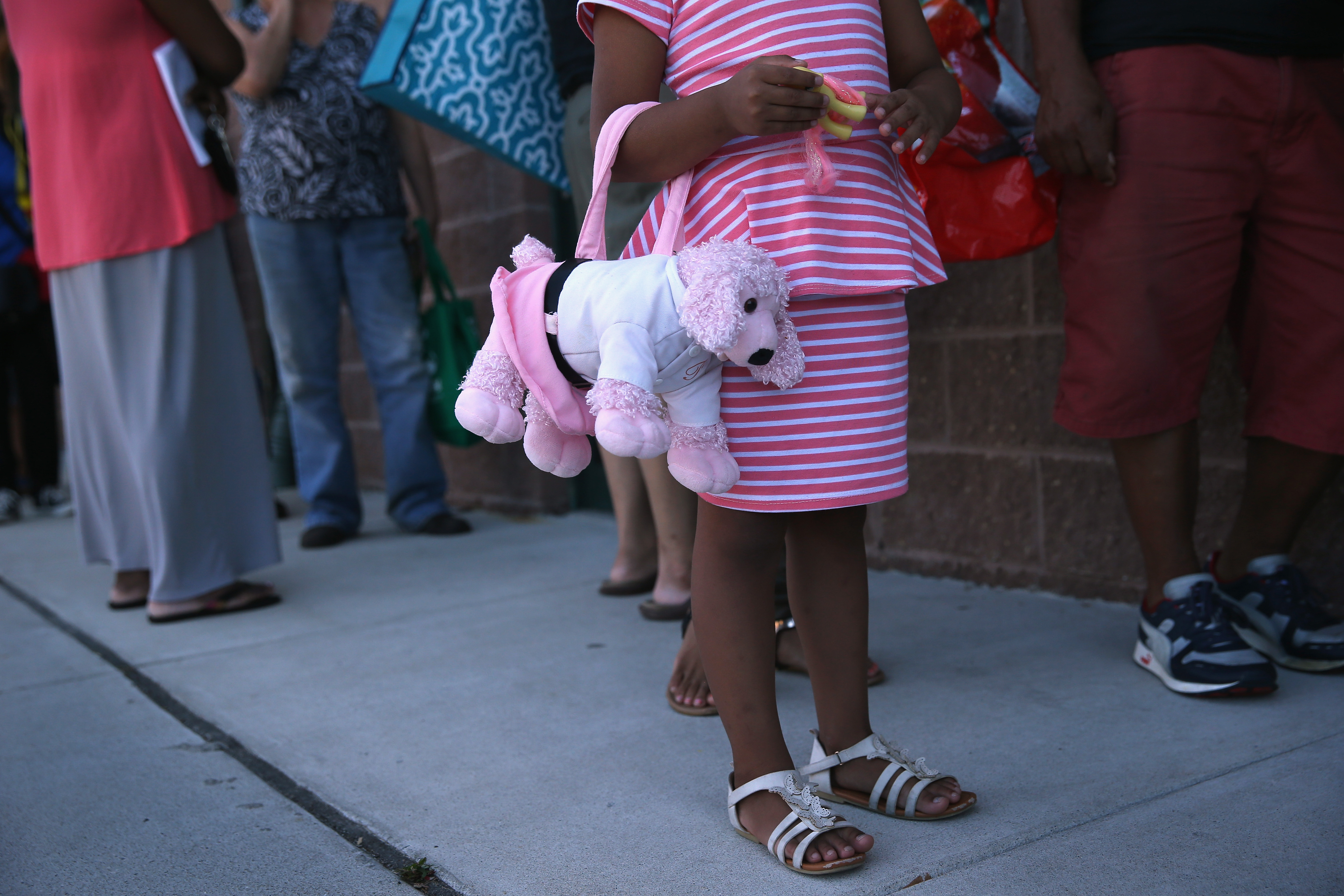 Low-income families stand in line to receive free fresh bread and produce at the Community Food Bank of New Jersey on August 28, 2015 in Egg Harbor, New Jersey.
