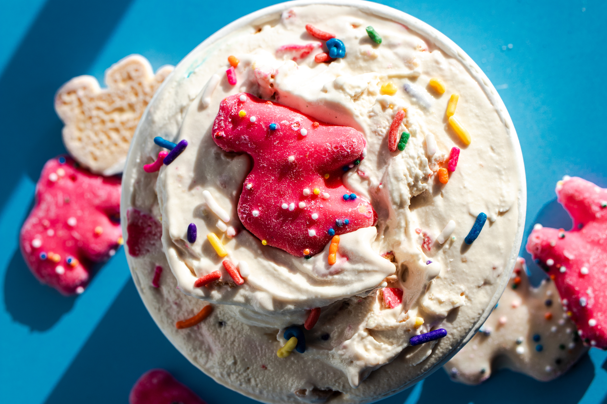 pint of ice cream with frosted animal cookies on top