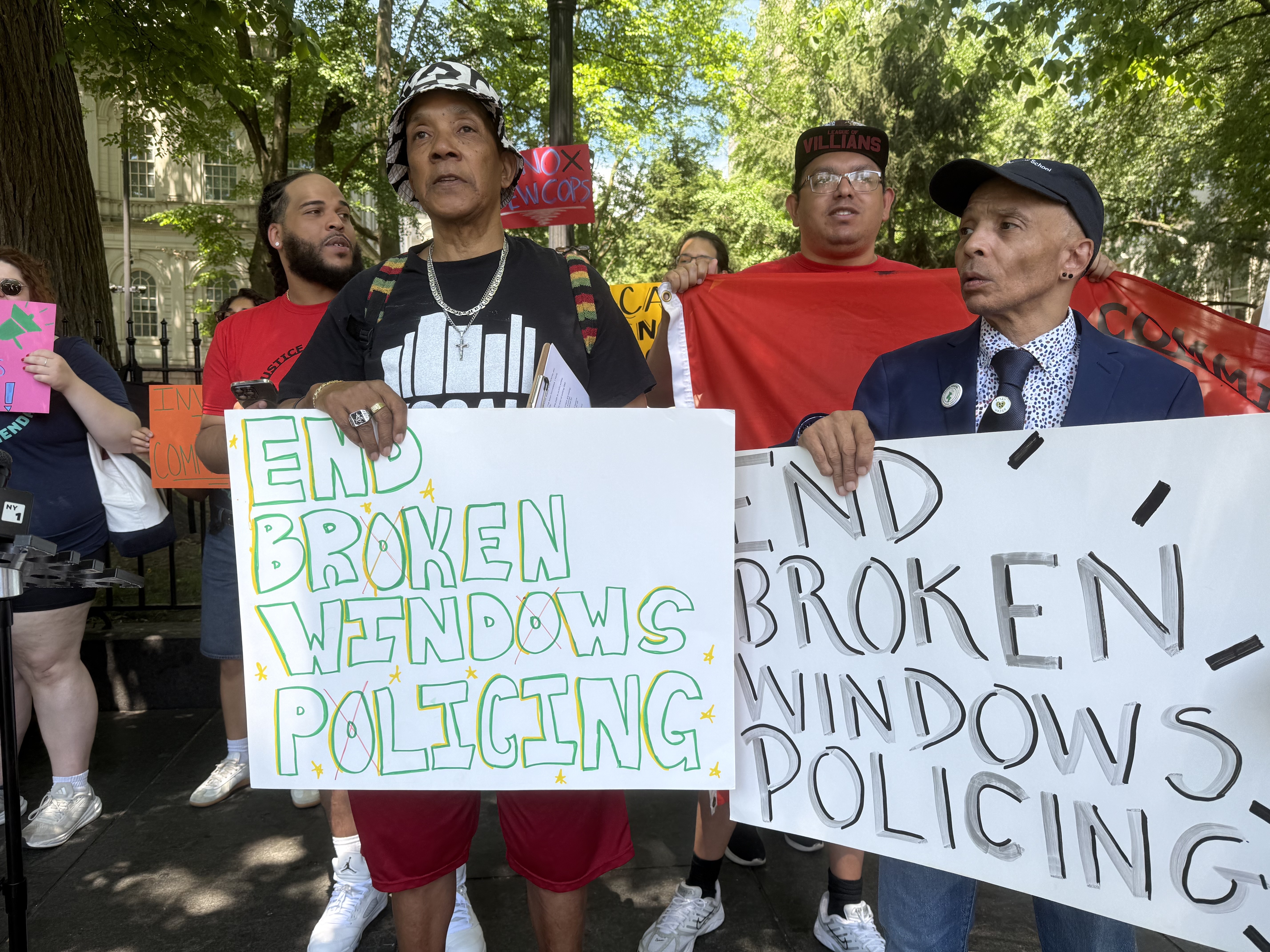 Demonstrators hold signs saying end broken windows.