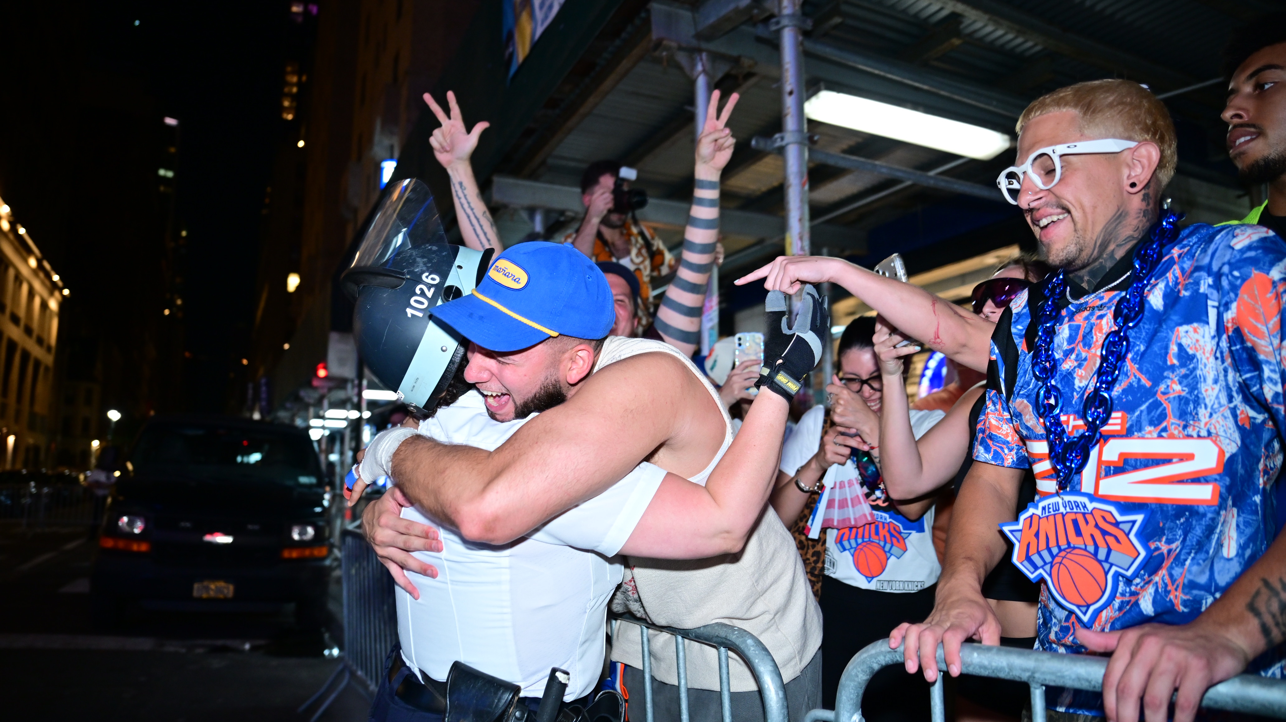 A Knicks fan embraces a police officer following the Knicks victory.