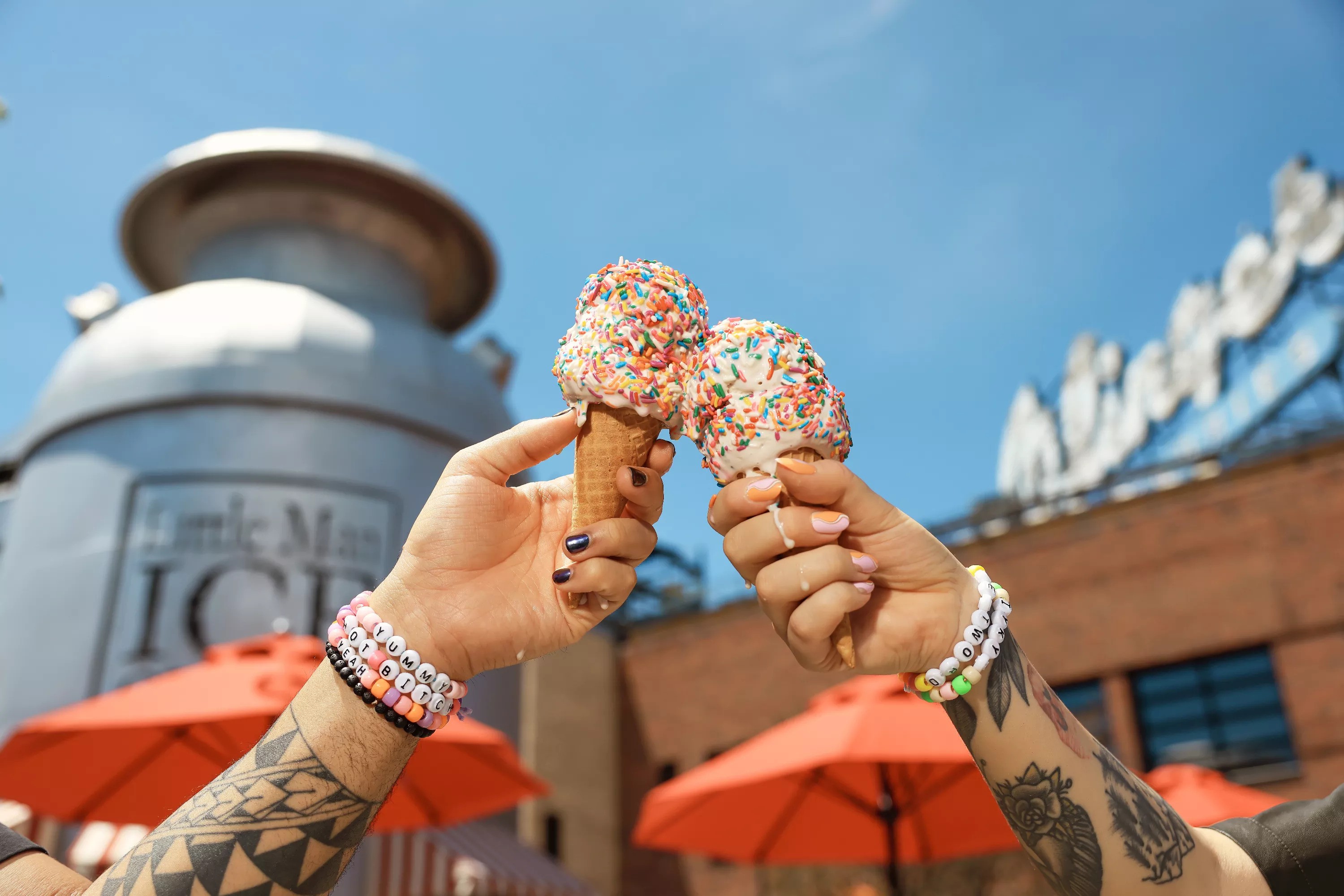 Two people holding ice cream cones in front of Little Man's milk bucket-shaped outpost