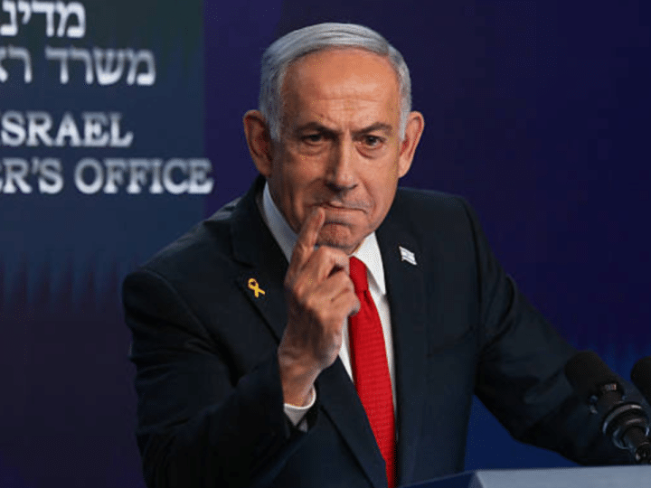 Benjamin Netanyahu, Israel prime minister, pointing his index finger from a podium, looking smart as if delivering a speech