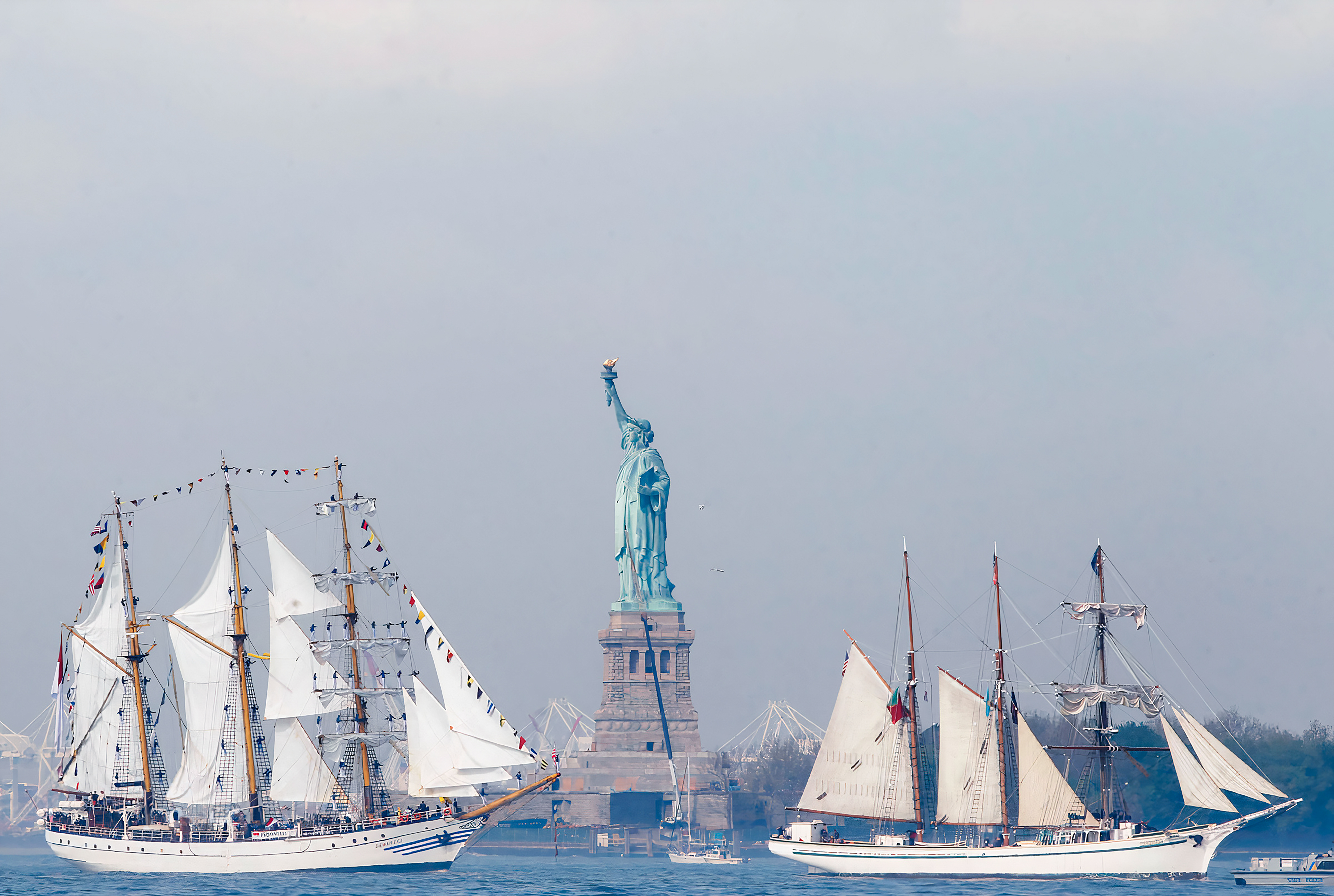 Two large ships surround the Statue of Liberty