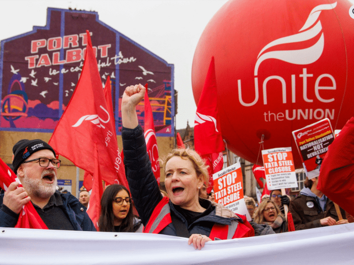 Unite members protest over Tata Steel with Sharon Graham up front, wearing a flourescent jacket and holding her fist in the air