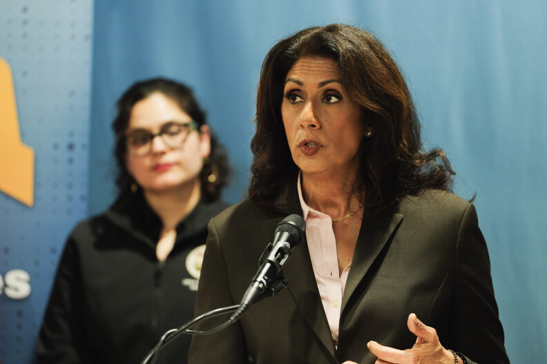 A woman stands at a podium and speaks.