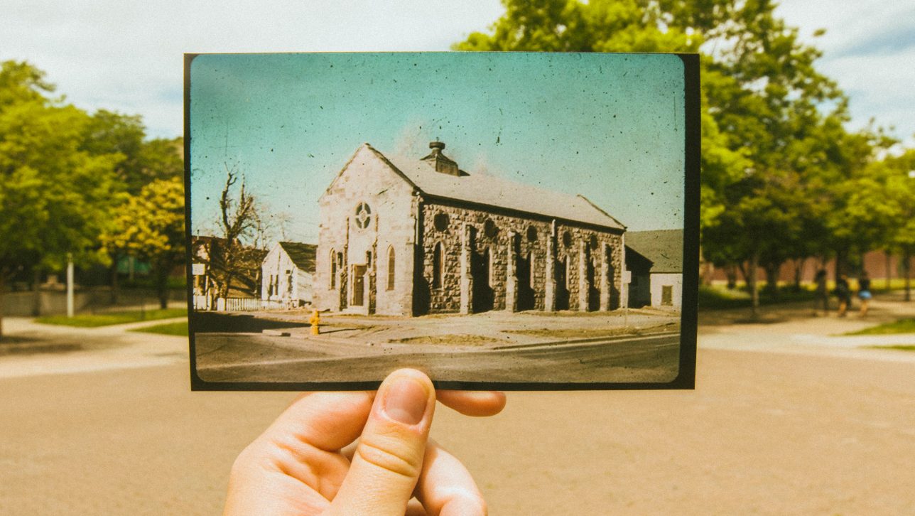 picture of old church in front of modern-day church