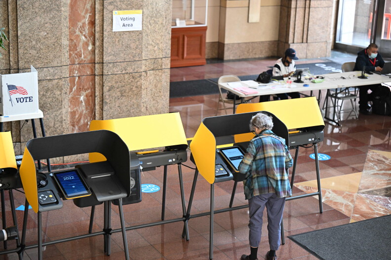 A voter prepares their ballot at a voting booth during early voting