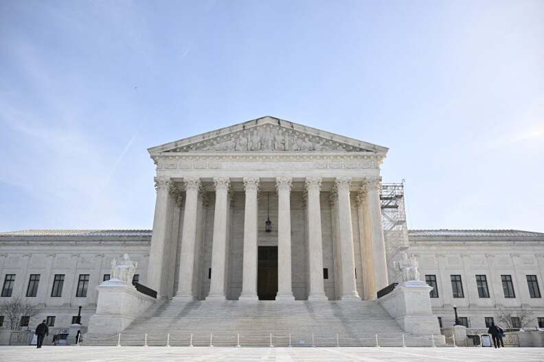 Thr front facade of the Supreme Court with chairs and columns.