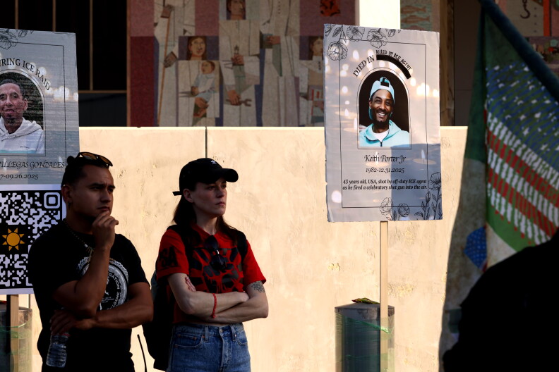 Two people stand near signs with Keith Porter Jr.'s face and name.