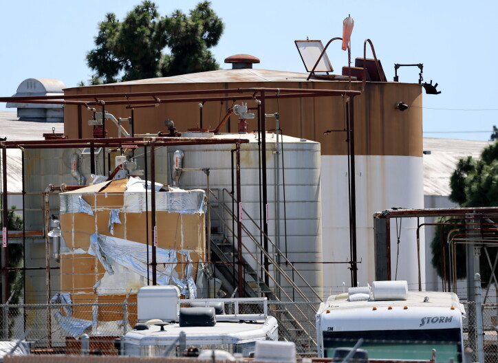 A peeling chemical tank is seen next to two other intact tanks at the GKN aerospace facility in Garden grove. An RV can be seen on the right hand side peeking into the picture. An even larger tank is behind the two other tanks.
