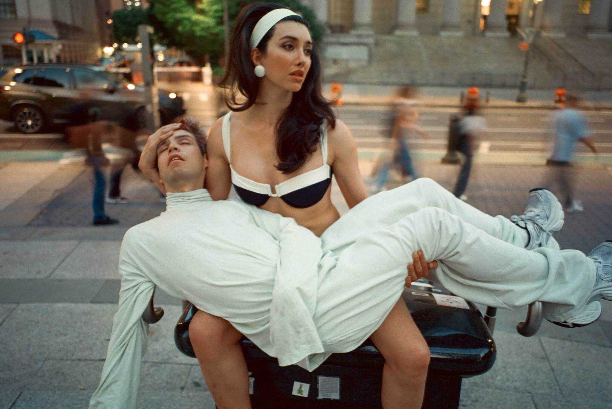 A woman holding a man in her arms walking up steps.