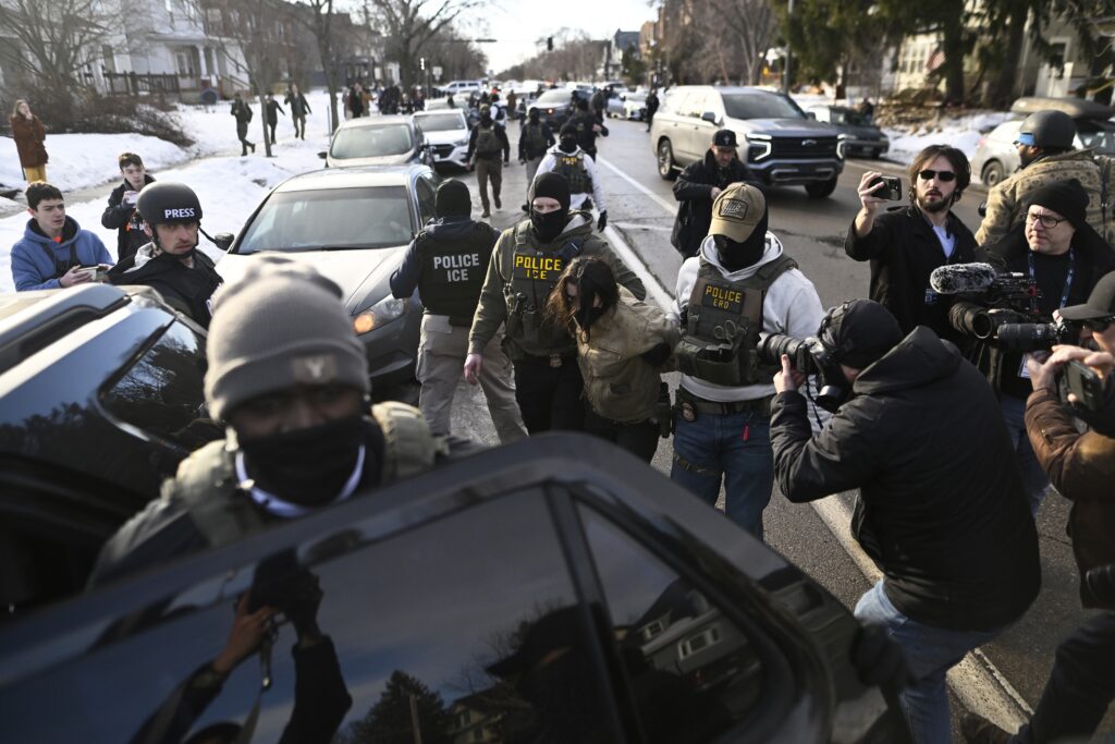 An observer is detained by ICE agents after they arrested two people from a residence on Jan. 13, 2026 in Minneapolis, Minnesota. (Photo by Stephen Maturen/Getty Images)