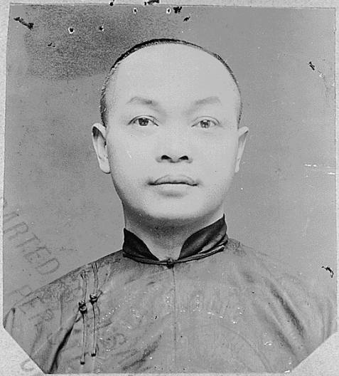 A black and white photo of a Chinese American man in traditional Chinese clothing.