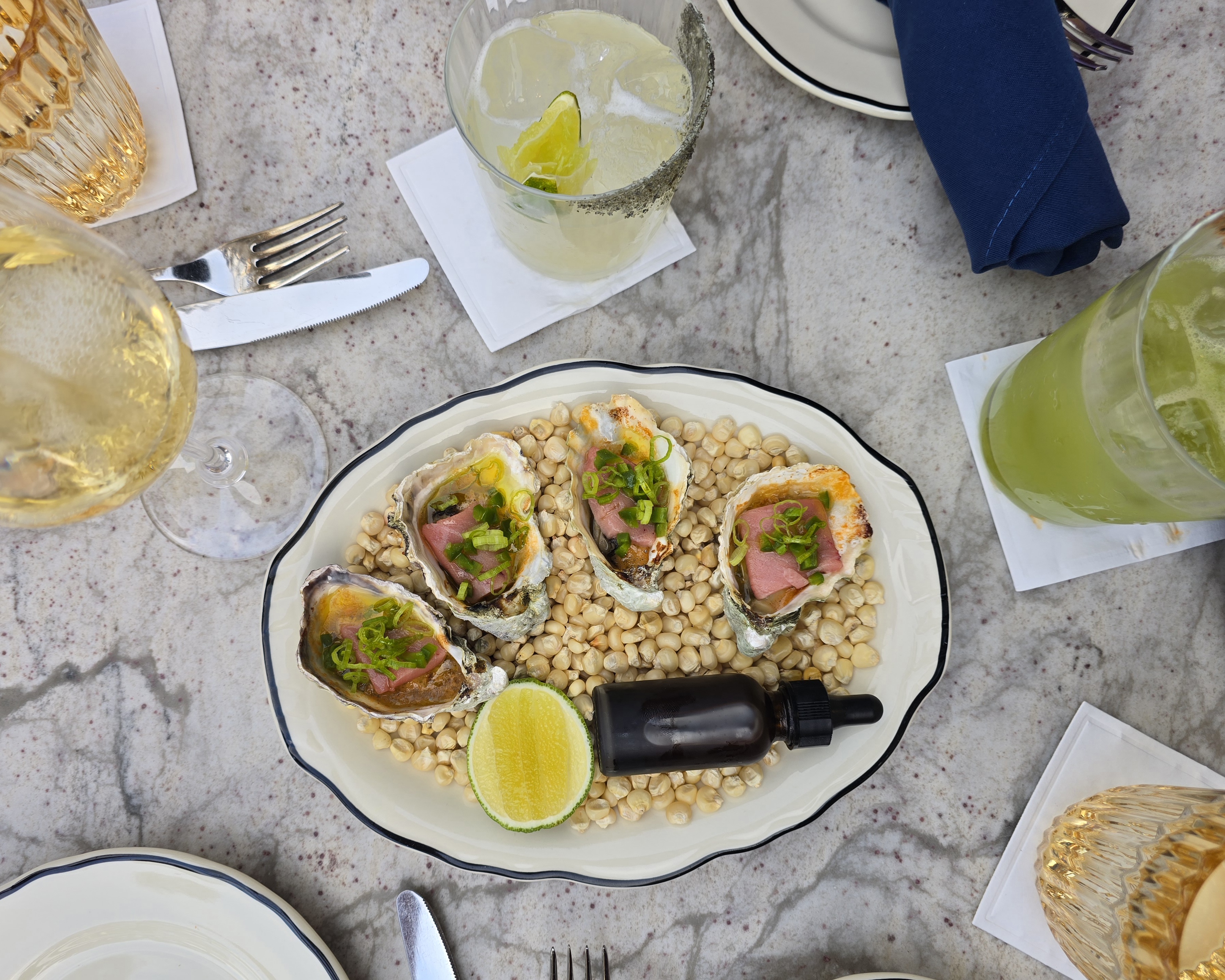 plate of four oysters topped with raw tuna
