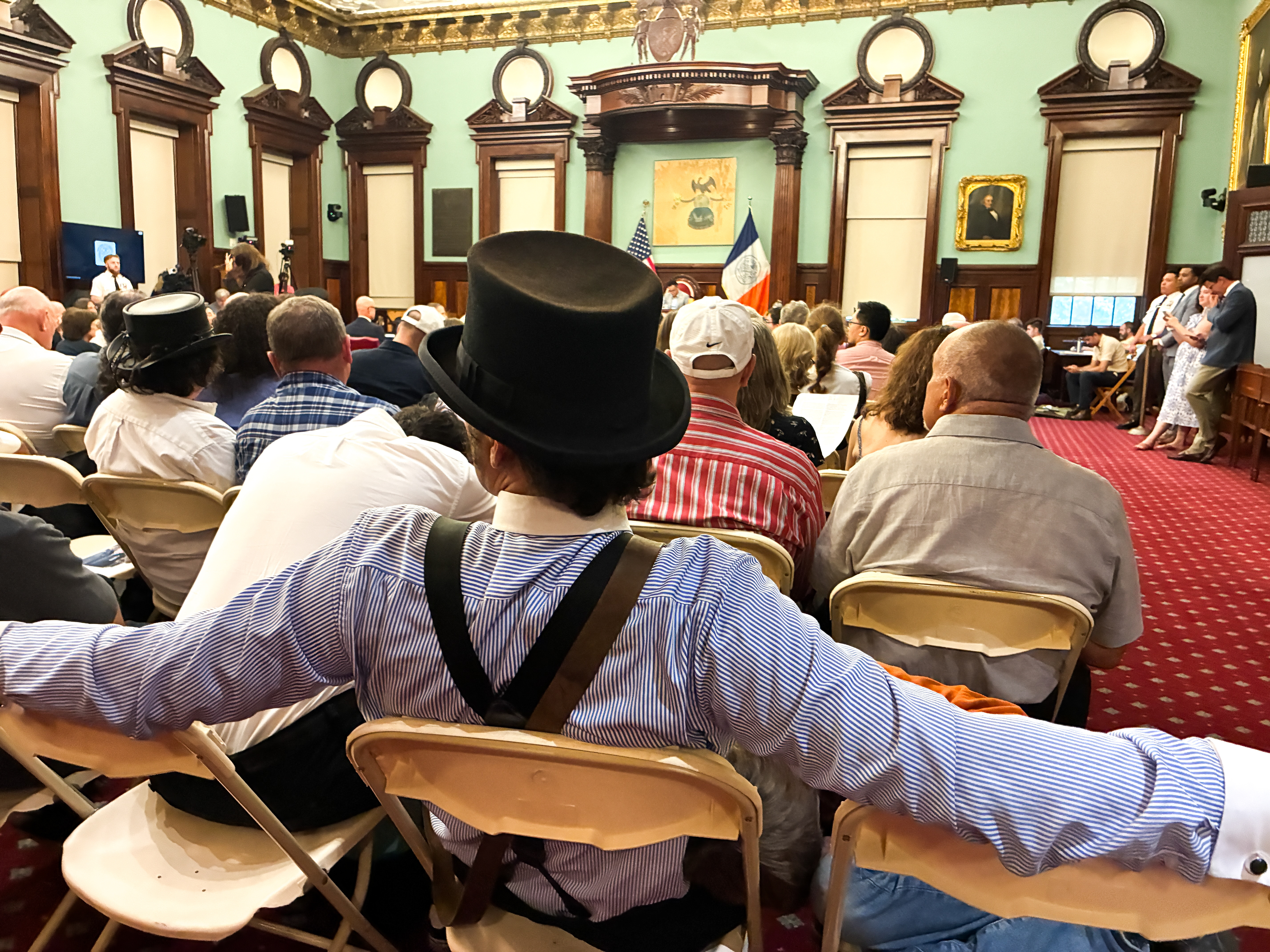 A man in a top hat at a Council Hearing.