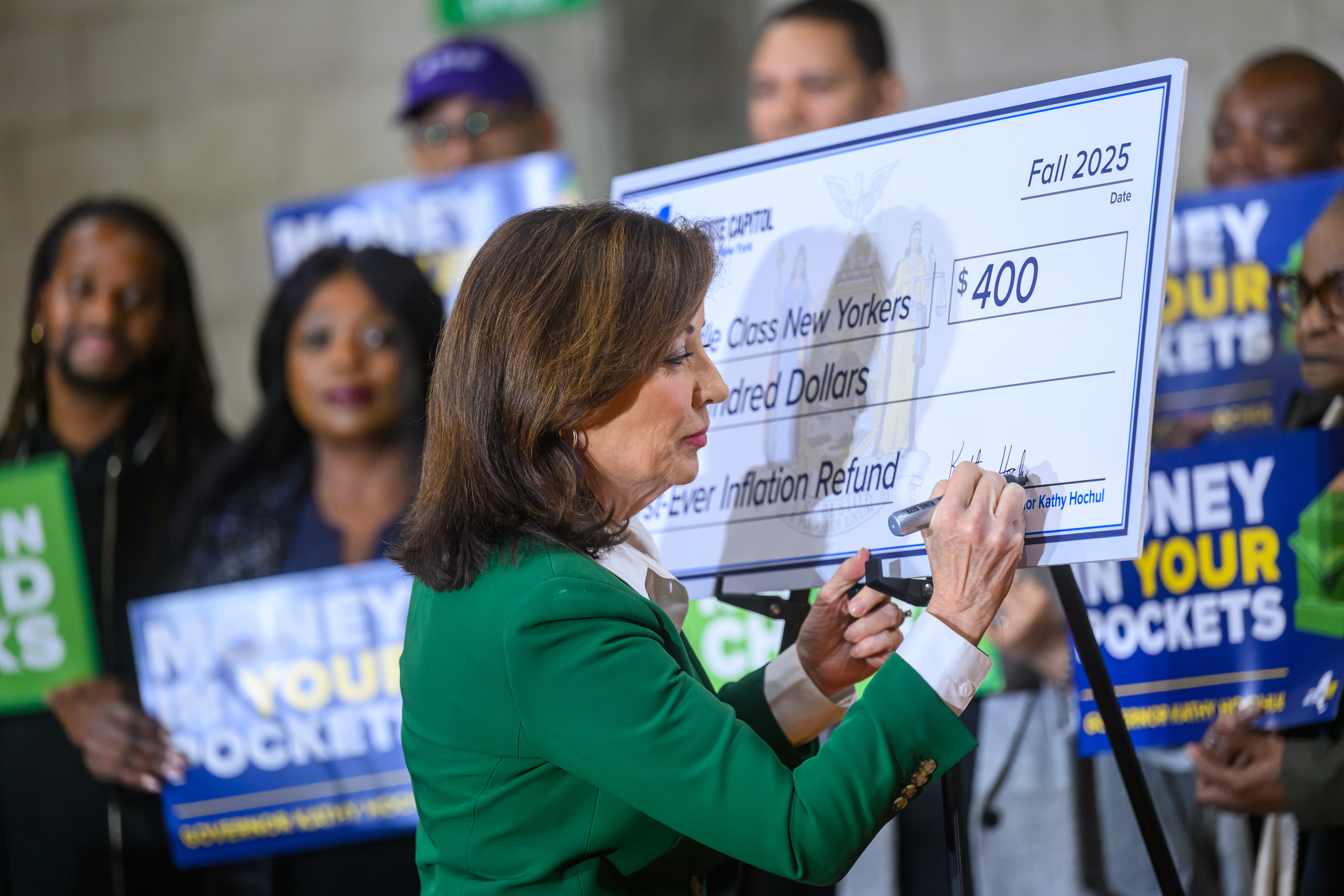 Gov. Hochul signs a big check.