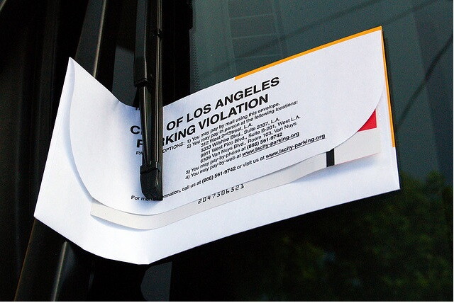 A City of Los Angeles parking ticket sits atop a car windshield.