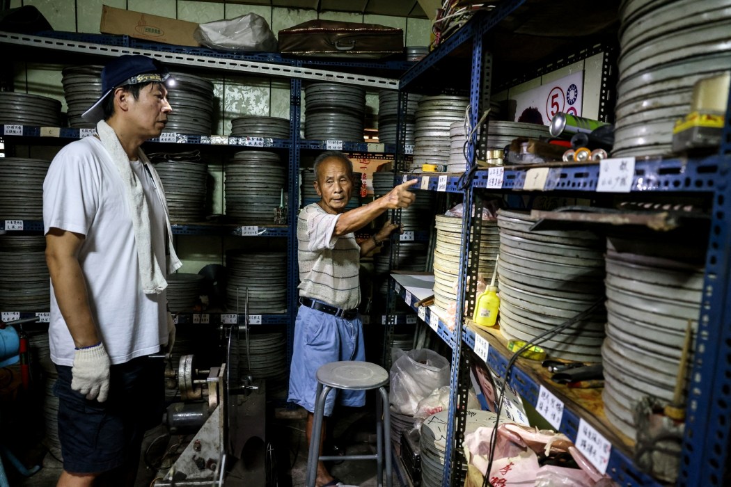 Film collector Wang Chin-ting (R) points out to old film reels as he discusses with a staff member from the Taiwan Film and Audiovisual Institute (TFAI) which reels will be collected for restoration.