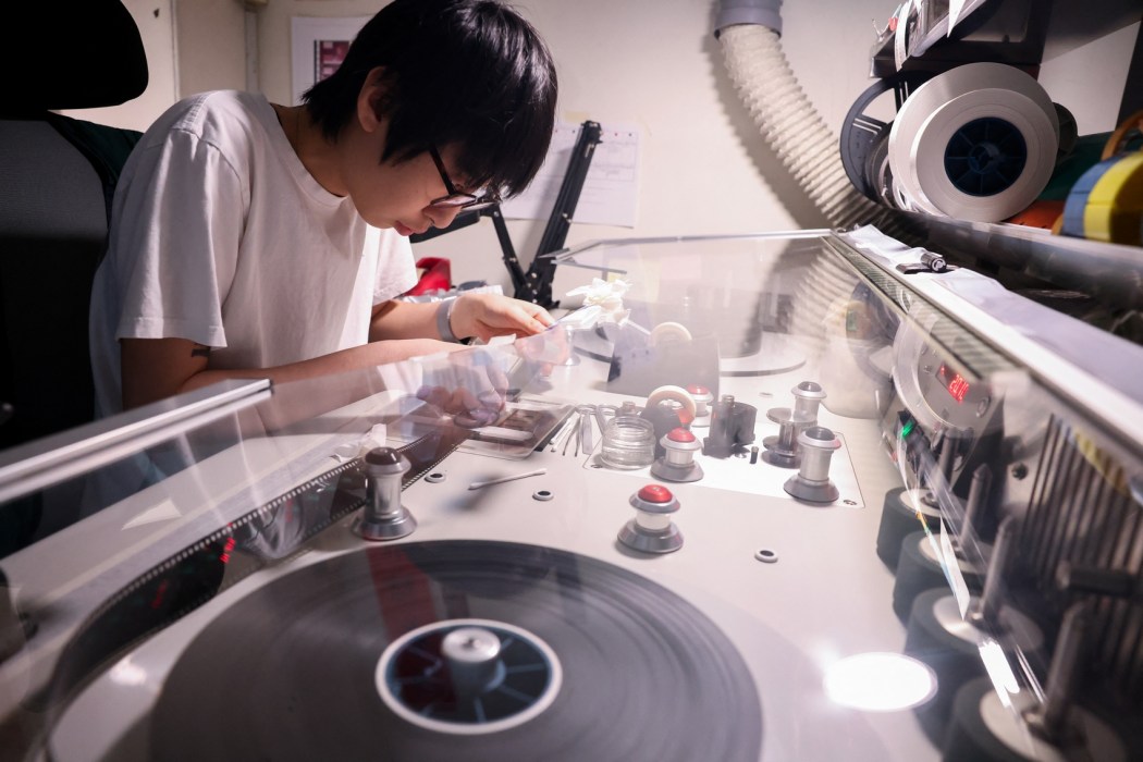 A technician at Preservation and Restoration Center repairs a Taiwanese-language film.