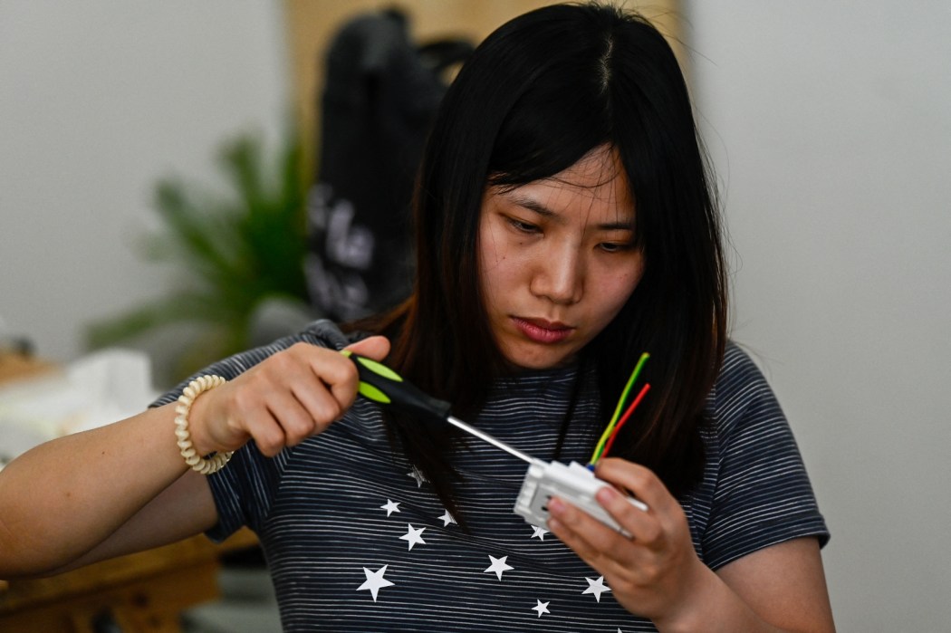 This picture taken on June 28, 2026 shows a woman practicing during an electricity course at the Mulan Build workshop in Hangzhou, in eastern China's Zhejiang province