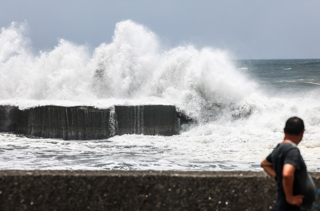 A man looks on as strong waves break along the coast in Yilan on July 10, 2026, as Typhoon Bavi moves toward northeastern Taiwan. Photo: I-Hwa Cheng/AFP.