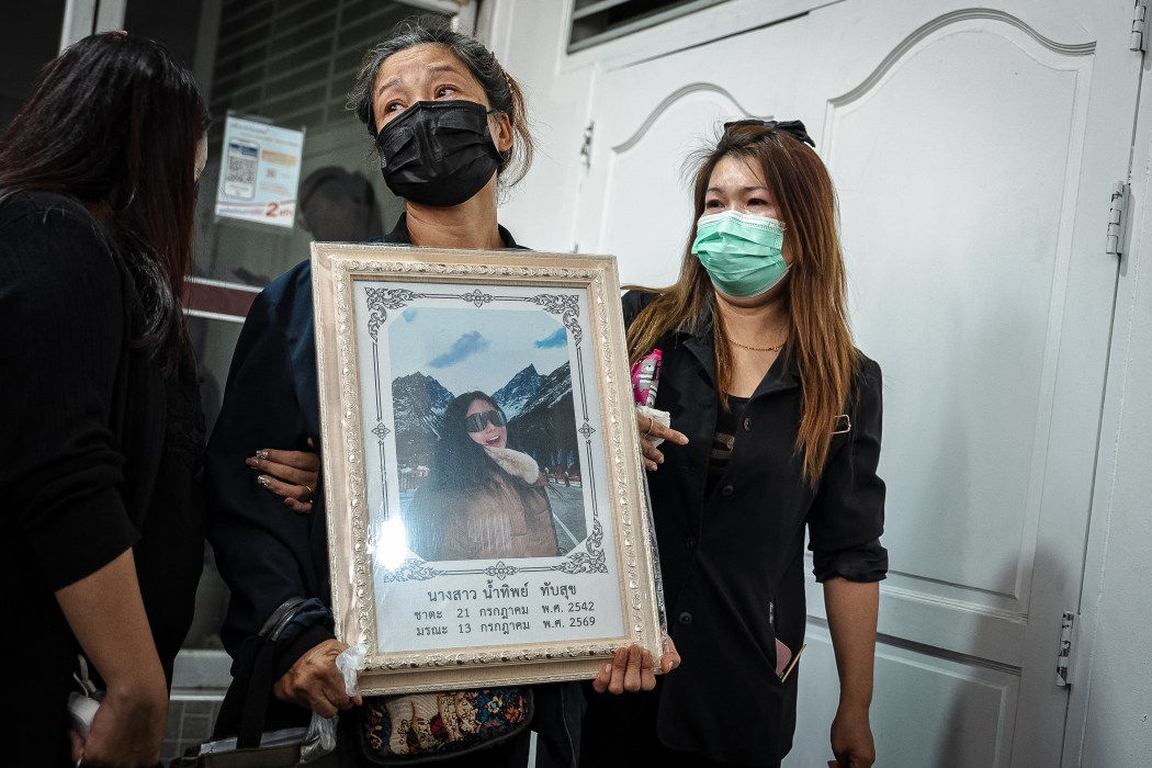 A relative hold a picture of victim killed in a bar fire at the Police General Hospital in Bangkok on July 14, 2026. Photo by Chanakarn Laosarakham/AFP.