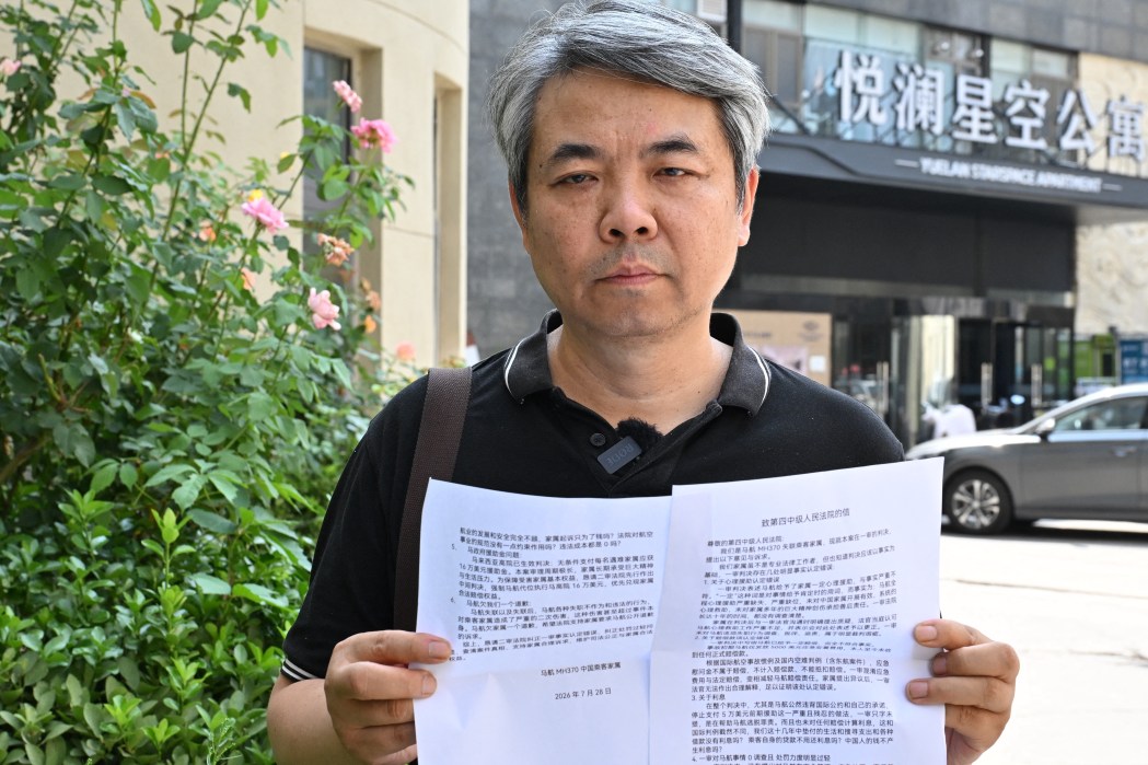 Jiang Hui, a media coordinator for Chinese passengers families, holds a statement next to the courthouse where relatives of passengers on board the missing Malaysia Airlines flight MH370 have a hearing in Beijing on July 28, 2026. Photo: Adek Berry/AFP.