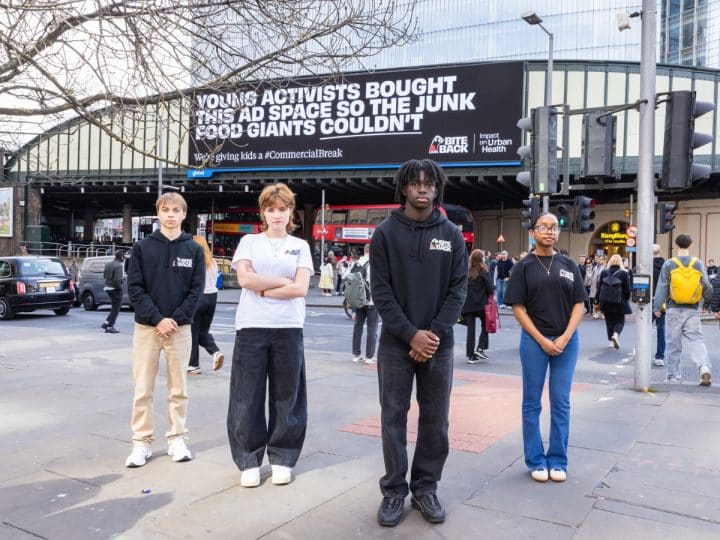 Bite Back campaigners in front of anti junk food ad on billboard