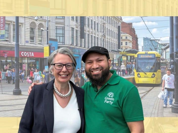 Geraldine Coggins and Mothin Ali of the Green Party smile next to one another in front of an image of a Manchester high street