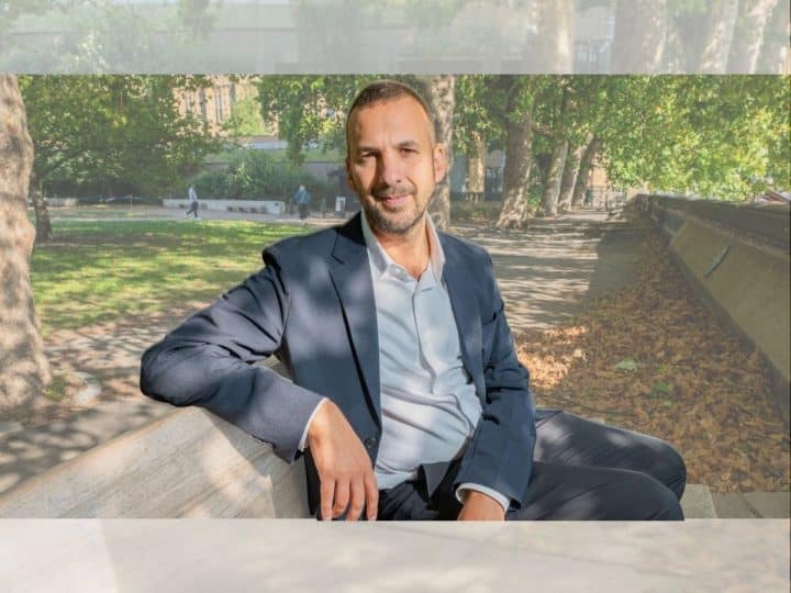 Zack Polanski of the Green Party sat on a bench outside in a relaxed manner posing for camera