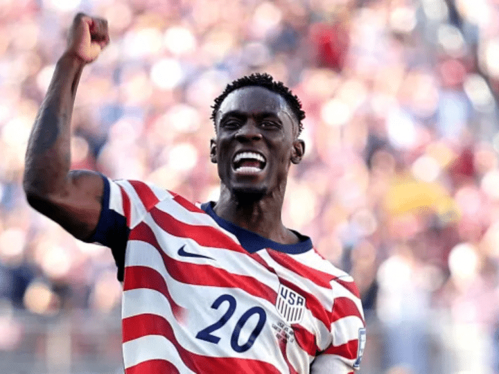 Folarin Balogun #20 of the United States celebrates scoring his team's first goal during the FIFA World Cup 2026 Round of 32 match between USA and Bosnia-Herzegovina on July 1, 2026 in Santa Clara, California, with a bicep flex