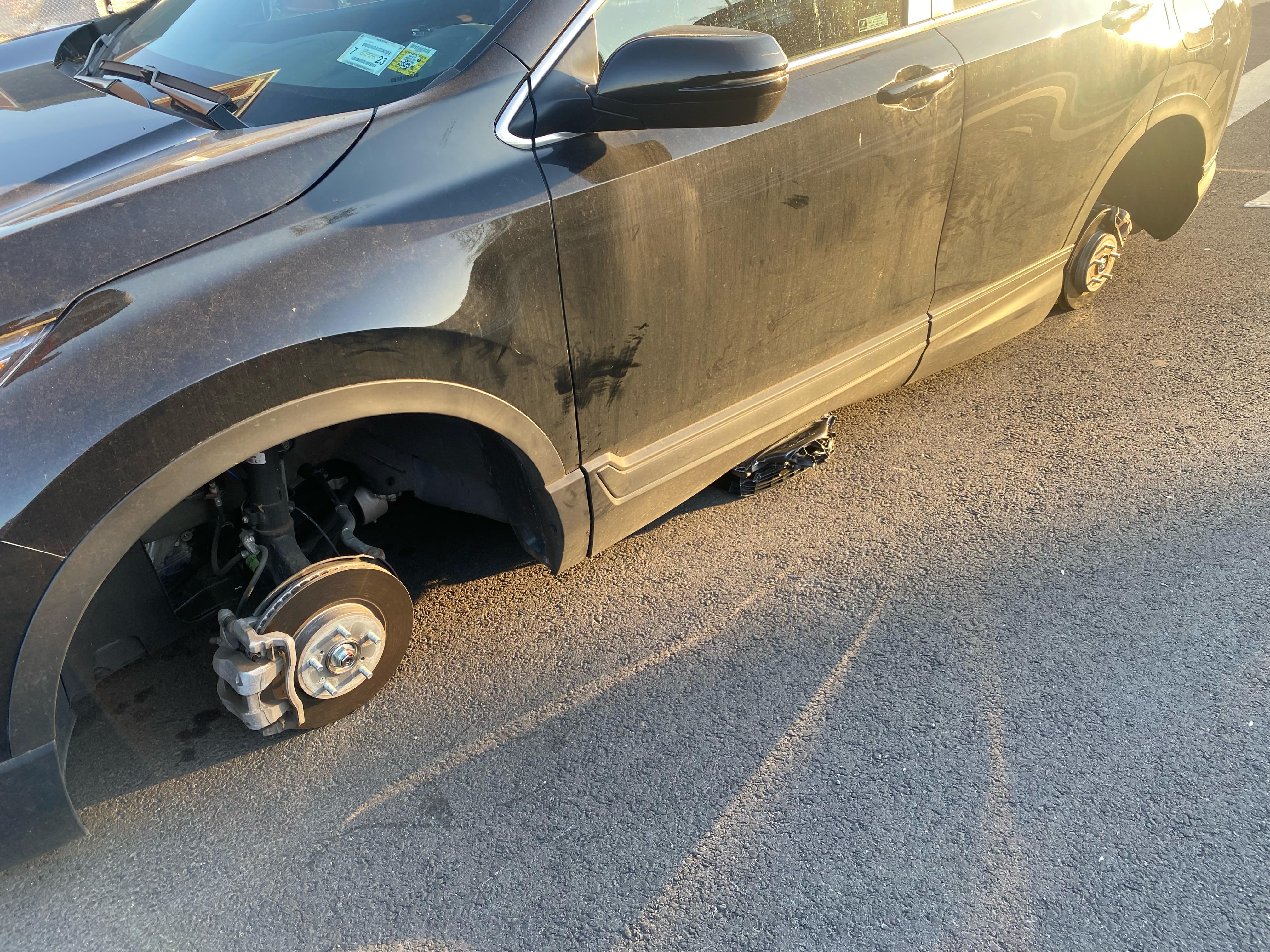 Jacked up car with tires stolen or removed on side of street, Queens, New York.