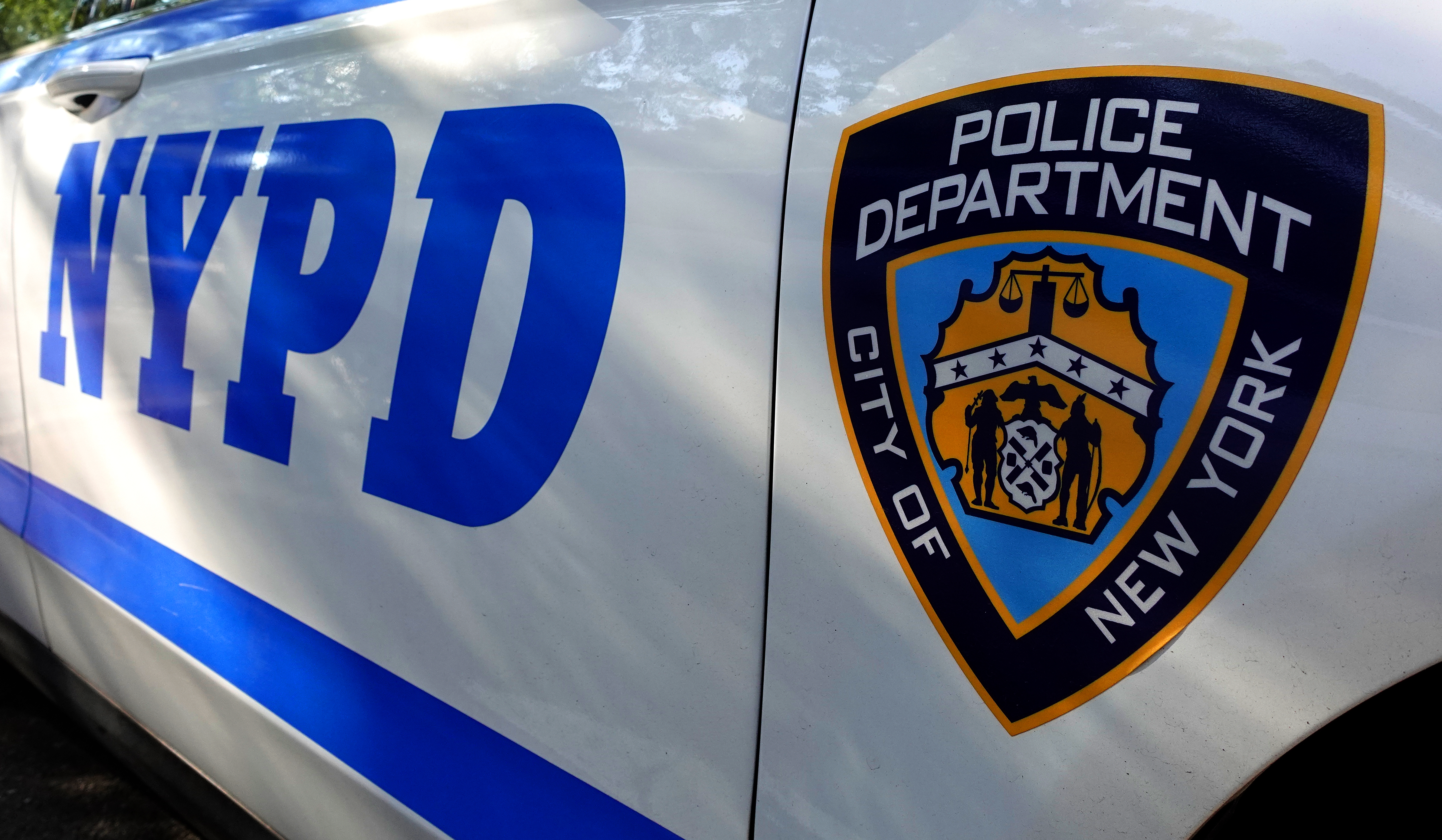 A logo for the NYPD is displayed on the side of a patrol car outside the 1st Precinct on July 20, 2026, in New York City.