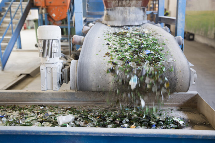 Glass particles move through a recycling facility. (Photo by Cylonphoto/Getty Images)