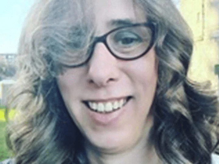 Close up selfie of Heather Herbert, who wears cat eye shaped glasses and has bouncy curls in her hair, and made mean comments online about Ann Widdecombe dying