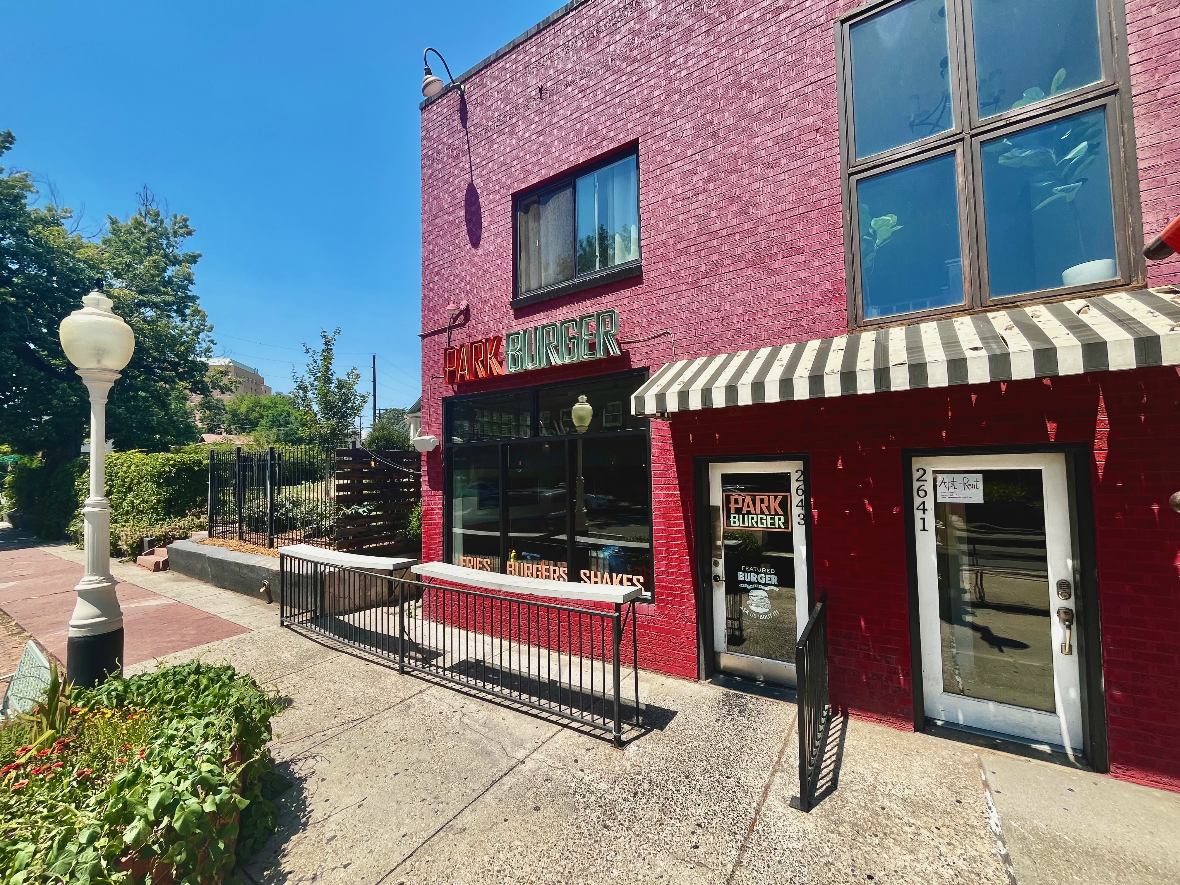 The front of the red brick Park Burger location in the Highland neighborhood on a sunny day.