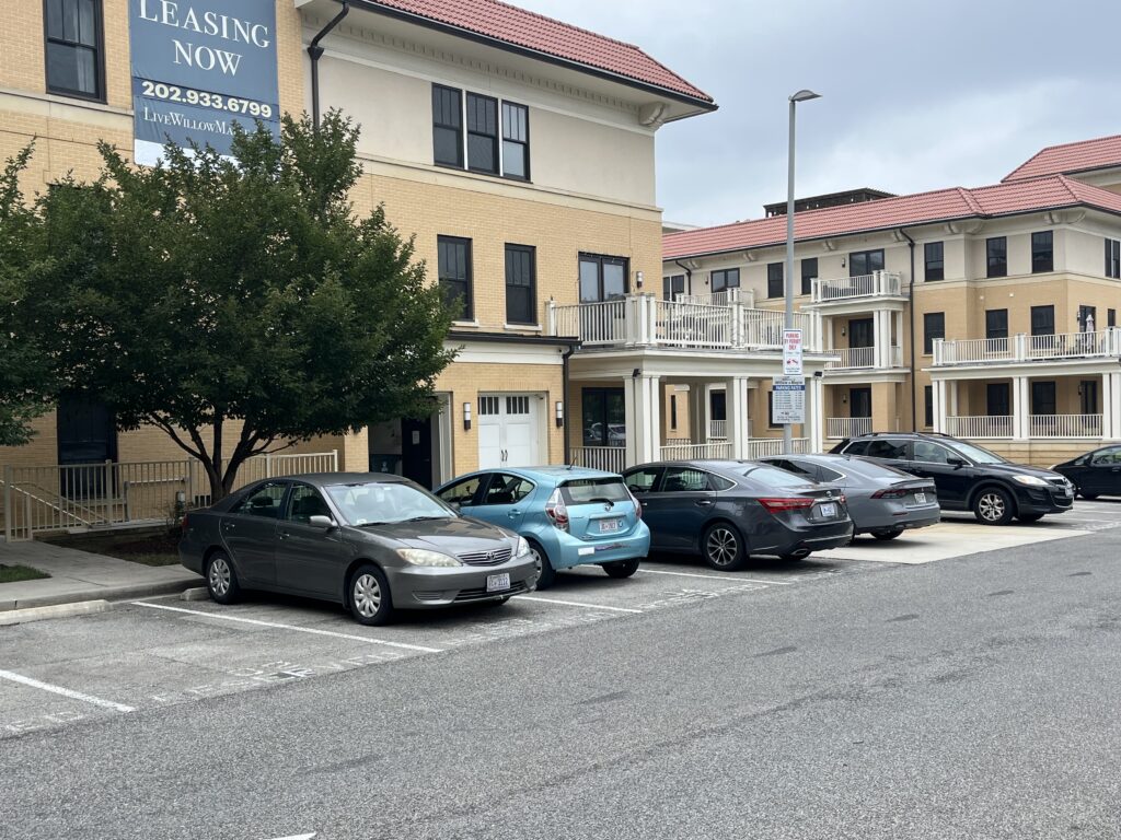 Cars in a parking lot at an apartment complex in Washington, D.C. In recent years, housing shortages have prompted more cities and states to scale back or even eliminate minimum parking requirements. (Photo by Scott S. Greenberger/Stateline)