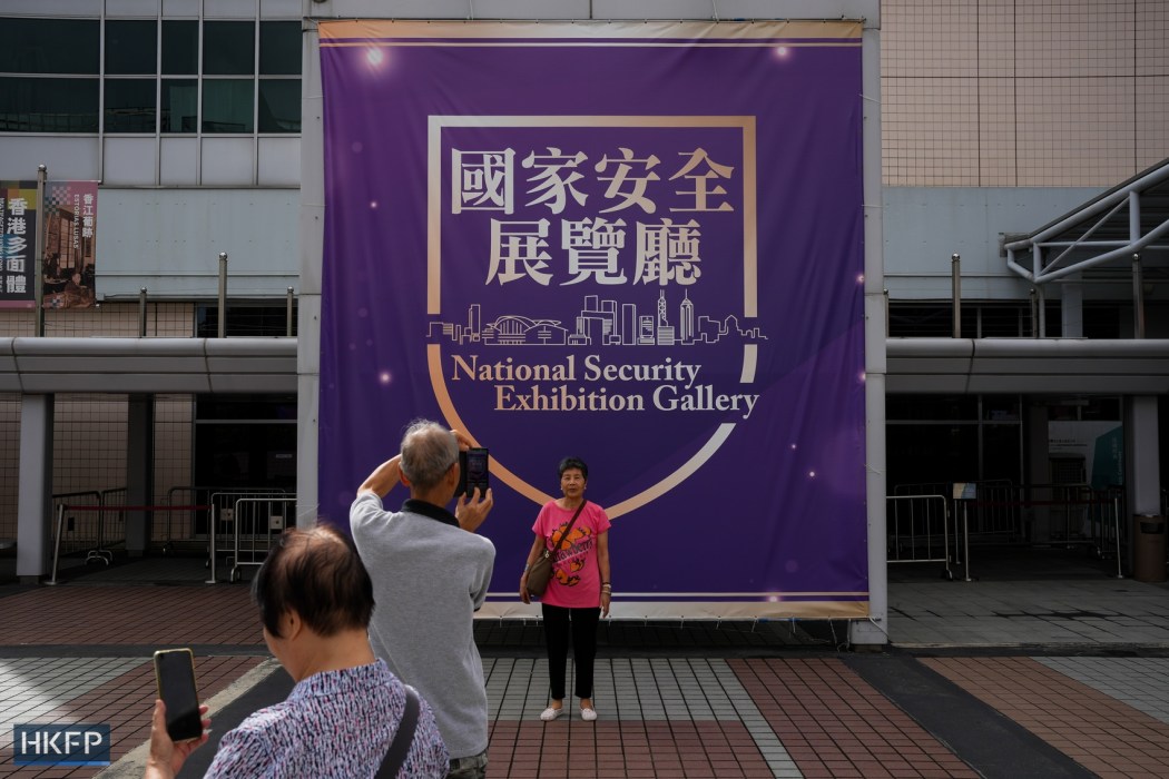 People take photos in front of a board introducing the national security exhibition at Hong Kong Museum of History on June 12, 2025. Photo: Kyle Lam/HKFP.
