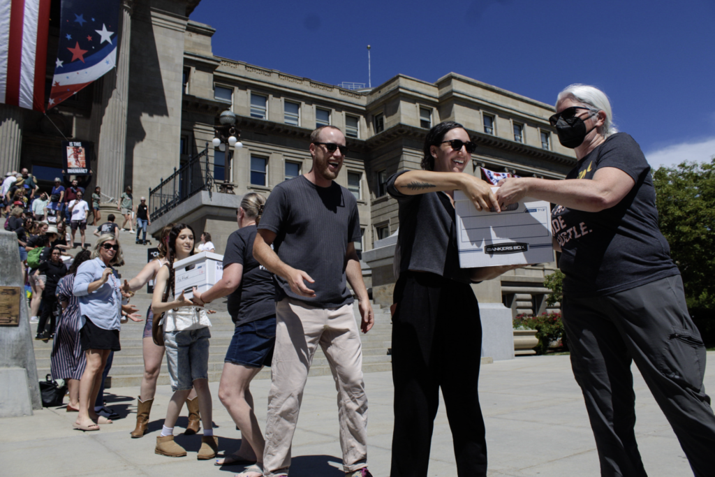 Volunteers pass boxes of signatures supporting a ballot initiative to end Idaho's ban on abortion outside the state capitol.