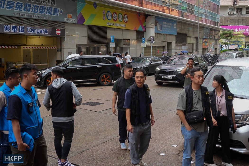 Police officers outside the building of Have a Nice Stay, on July 15, 2026. Photo: Kyle Lam/HKFP.