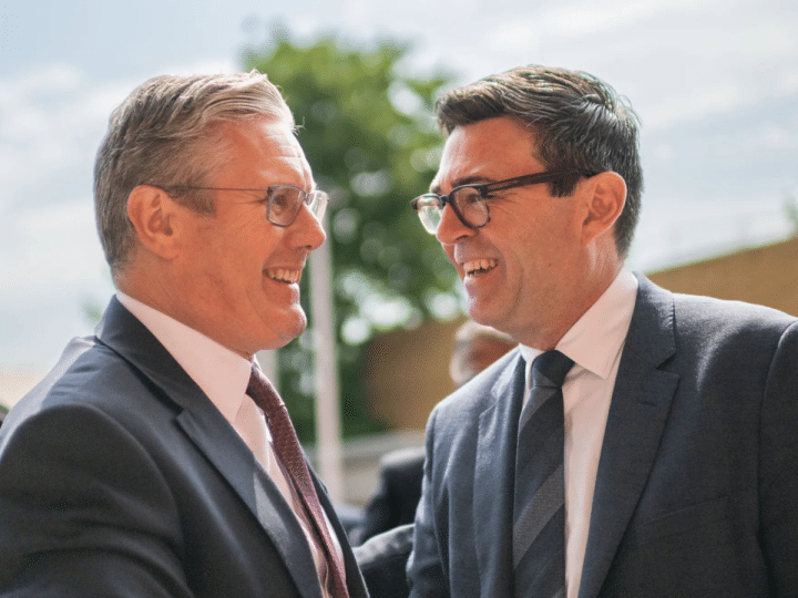 Keir Starmer and Andy Burnham greeting one another and smiling in close proximity