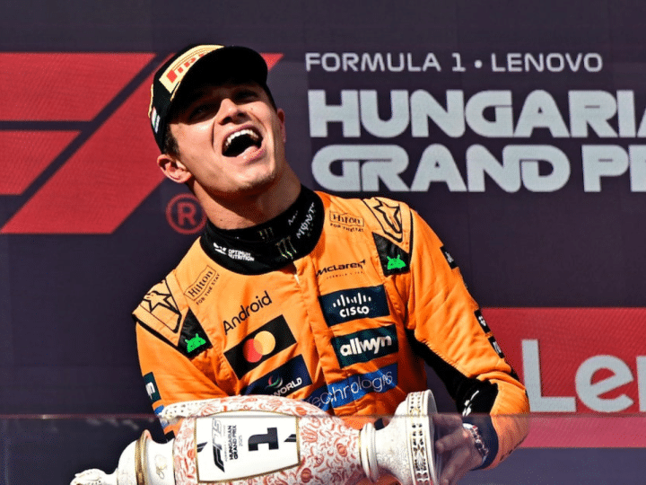 Lando Norris celebrates on the podium with a trophy after winning the Hungarian Grand Prix