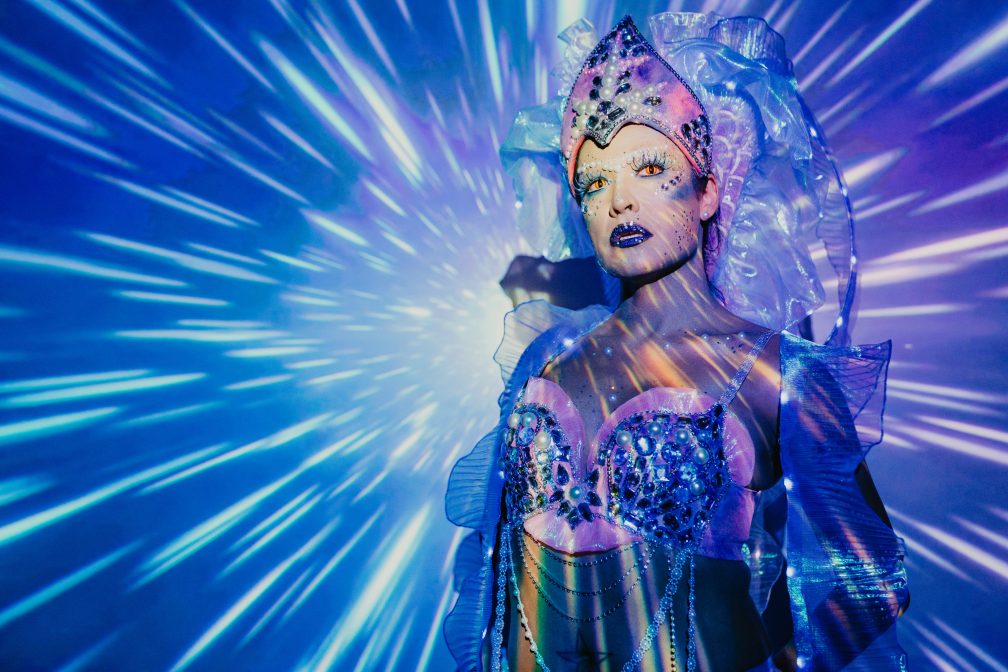 A person poses in a sci-fi setting