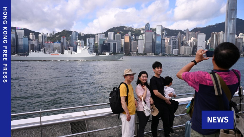 A family poses for photos as the Chinese People's Liberation Army (PLA) Navy guided-missile destroyer Nanning (162) sails through Victoria Harbour during its arrival in Hong Kong for a five-day visit on July 2, 2026. Photo: Peter Parks/AFP.