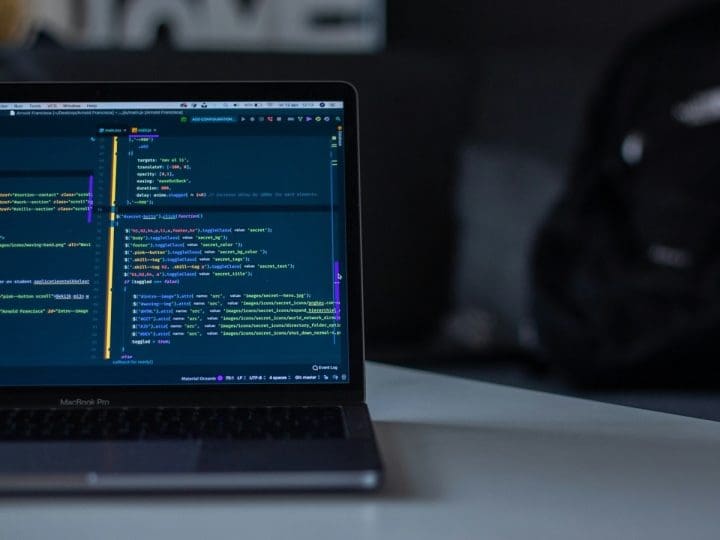 A laptop computer on a desk with code on the screen to visualise the hacker story