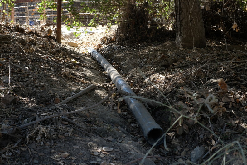 A PVC pipe in a dirt ditch.
